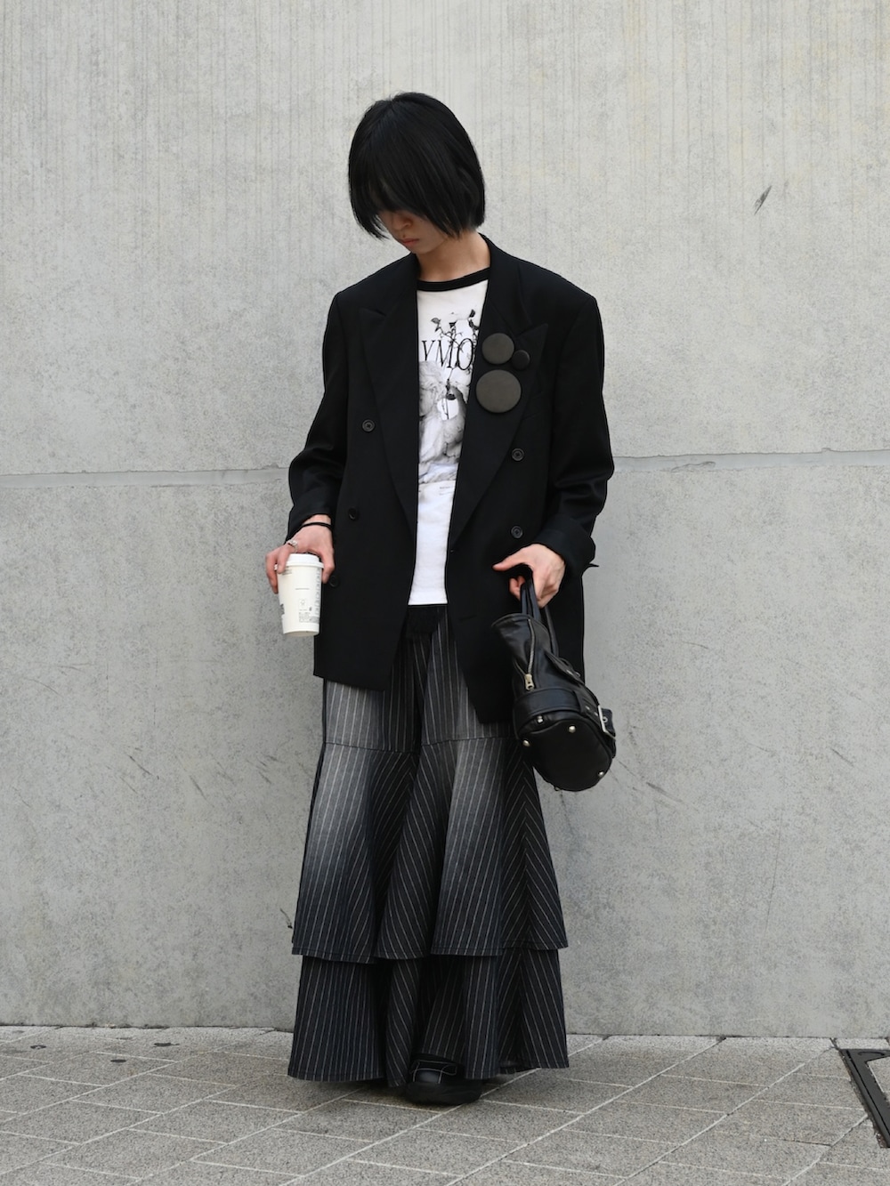 ブラック系のTシャツ/カットソー、ブラック系のテーラードジャケット、ブラック系のトートバッグを着用したメンズの春コーディネートの3枚目の写真