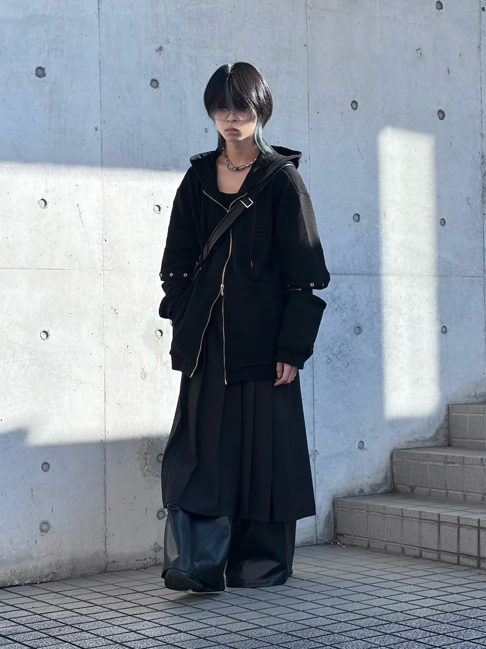 ブラック系のパーカー、ブラック系のショルダーバッグ、ブラック系のスカートを着用したメンズの冬コーディネートの4枚目の写真