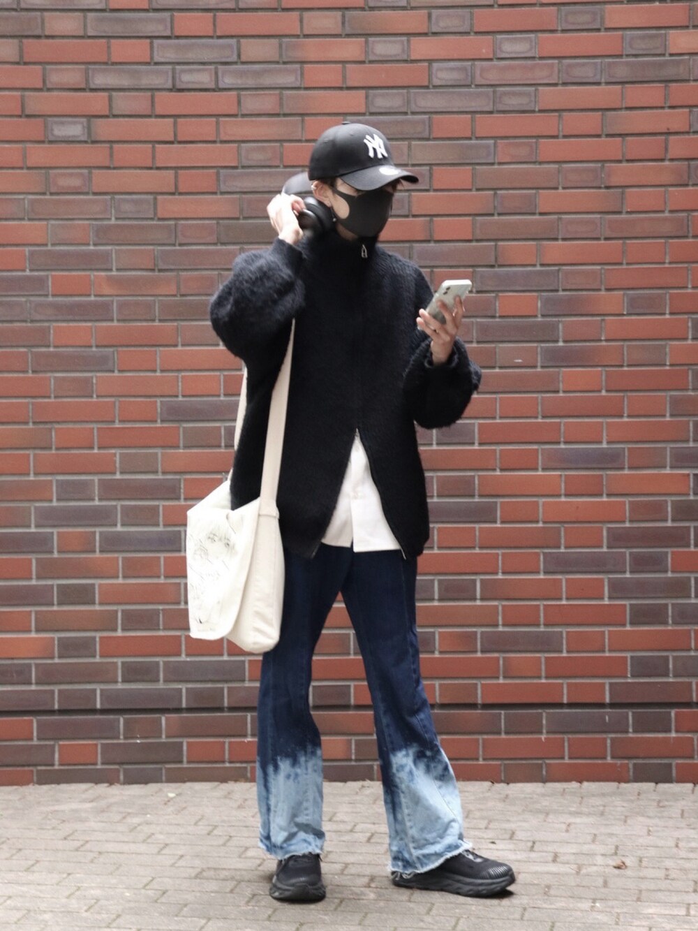 ブルー系のデニムパンツ、ホワイト系のシャツ/ブラウス、ブラック系のニット/セーターを着用したメンズの春コーディネートの3枚目の写真