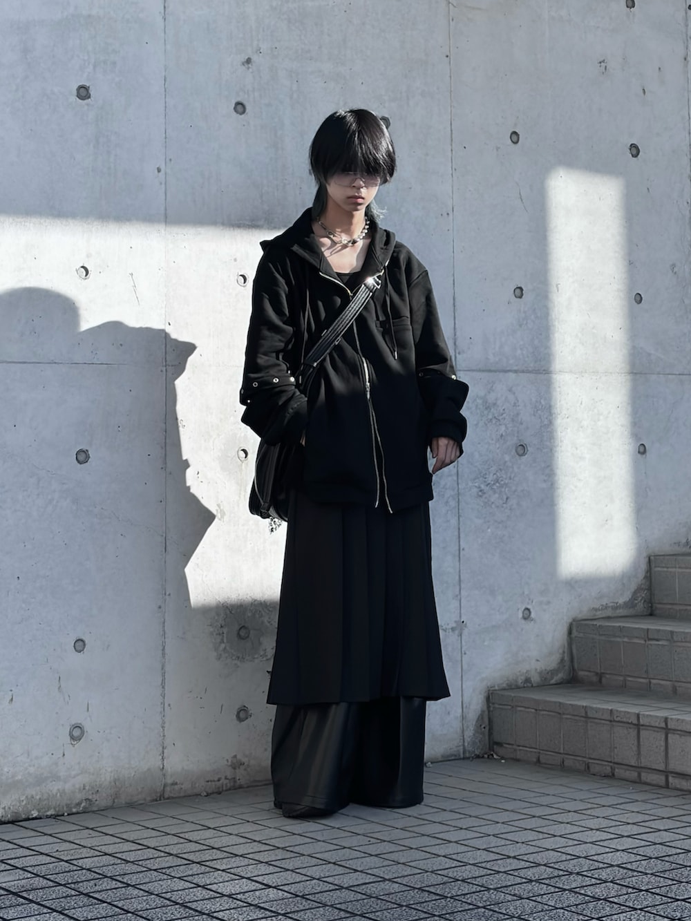 ブラック系のパーカー、ブラック系のショルダーバッグ、ブラック系のスカートを着用したメンズの冬コーディネートの2枚目の写真