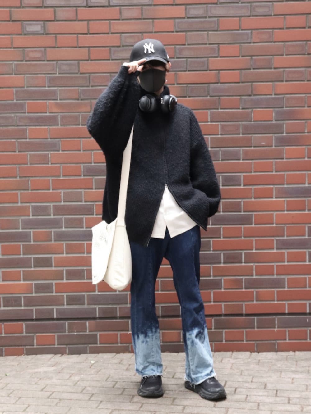 ブルー系のデニムパンツ、ホワイト系のシャツ/ブラウス、ブラック系のニット/セーターを着用したメンズの春コーディネートの2枚目の写真
