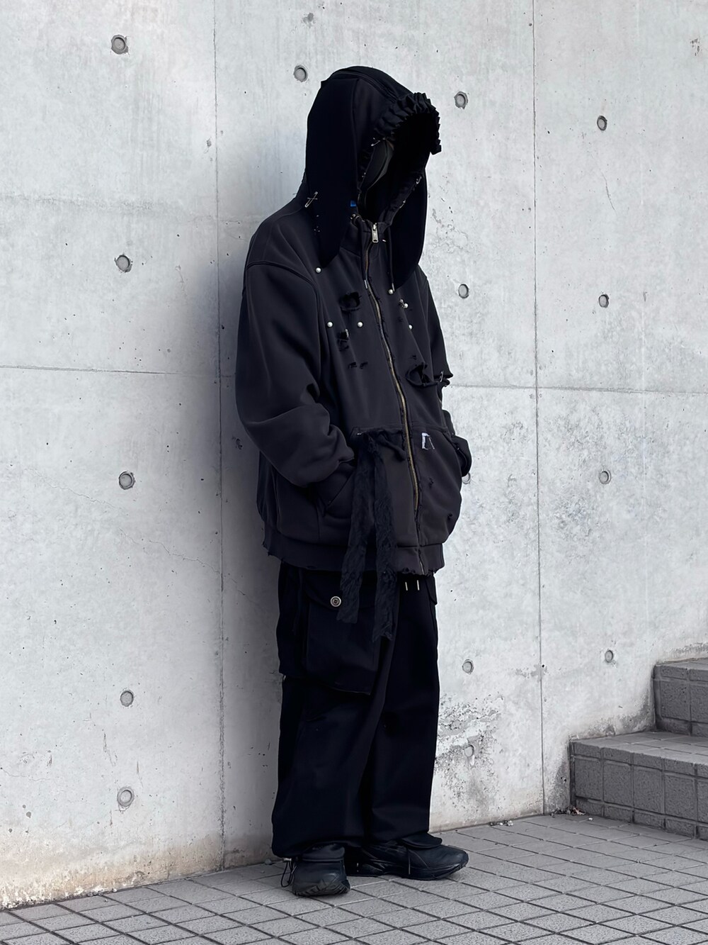 ブラック系のパーカー、ブラック系のカーゴパンツ、ブラック系のスニーカーを着用したメンズの冬コーディネートの3枚目の写真