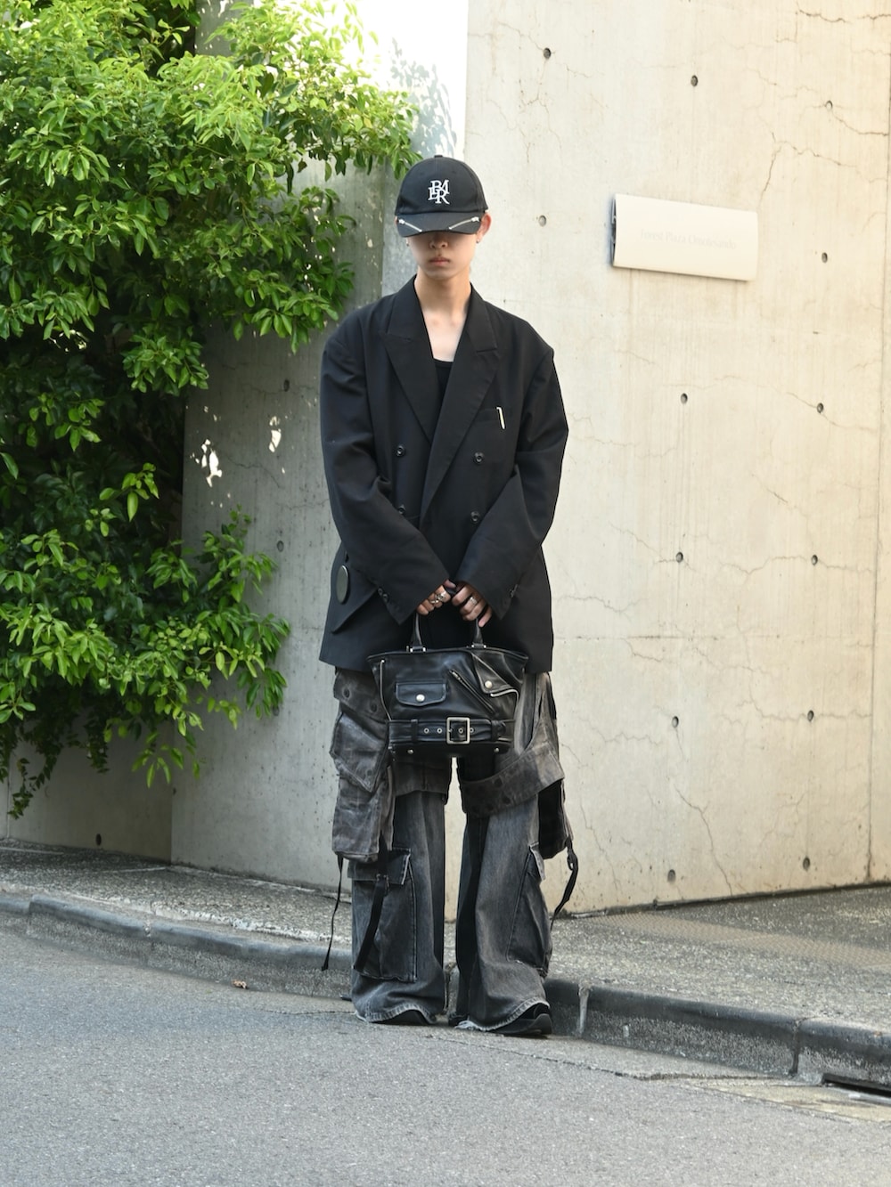 ブラック系のテーラードジャケット、グレー系のカーゴパンツ、ブラック系のトートバッグを着用したメンズの秋コーディネートの2枚目の写真