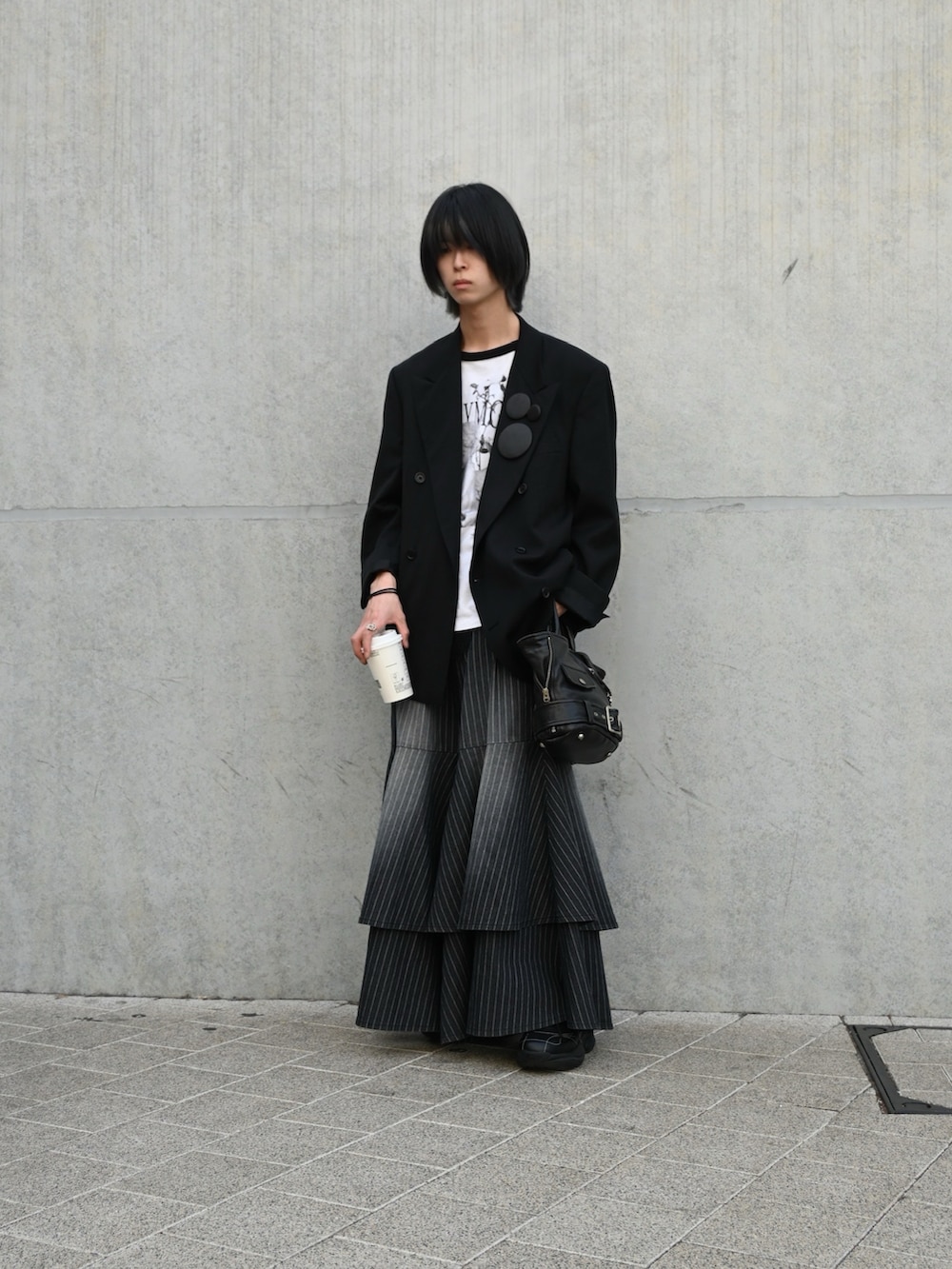 ブラック系のTシャツ/カットソー、ブラック系のテーラードジャケット、ブラック系のトートバッグを着用したメンズの春コーディネートの2枚目の写真