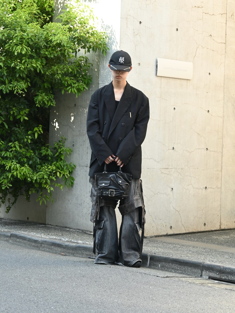 ブラック系のテーラードジャケット、グレー系のカーゴパンツ、ブラック系のトートバッグを着用したメンズの秋コーディネートの3枚目の写真