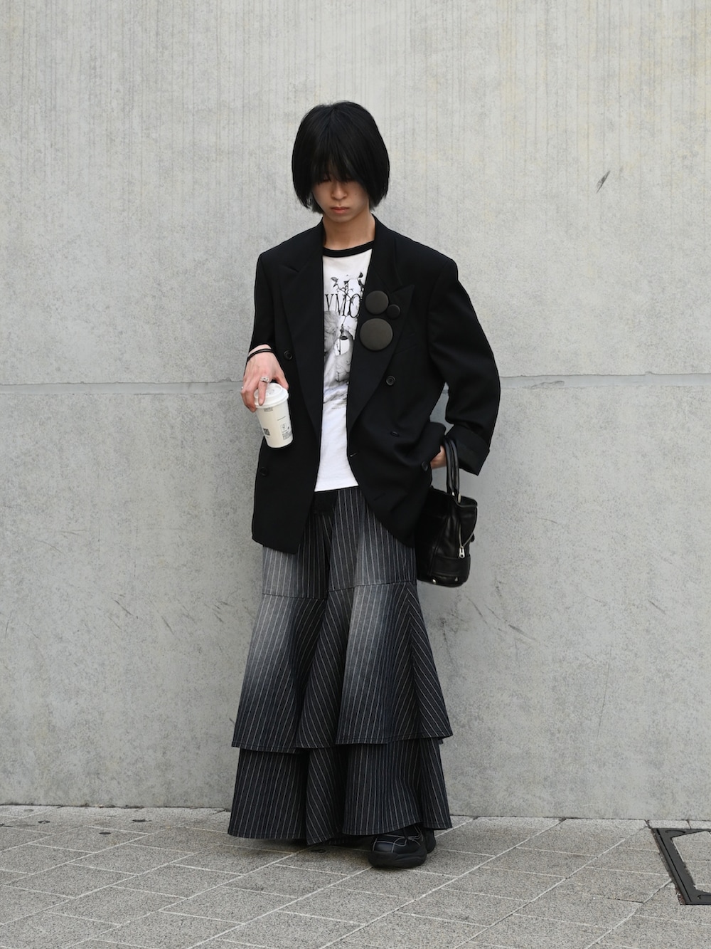 ブラック系のTシャツ/カットソー、ブラック系のテーラードジャケット、ブラック系のトートバッグを着用したメンズの春コーディネートの4枚目の写真