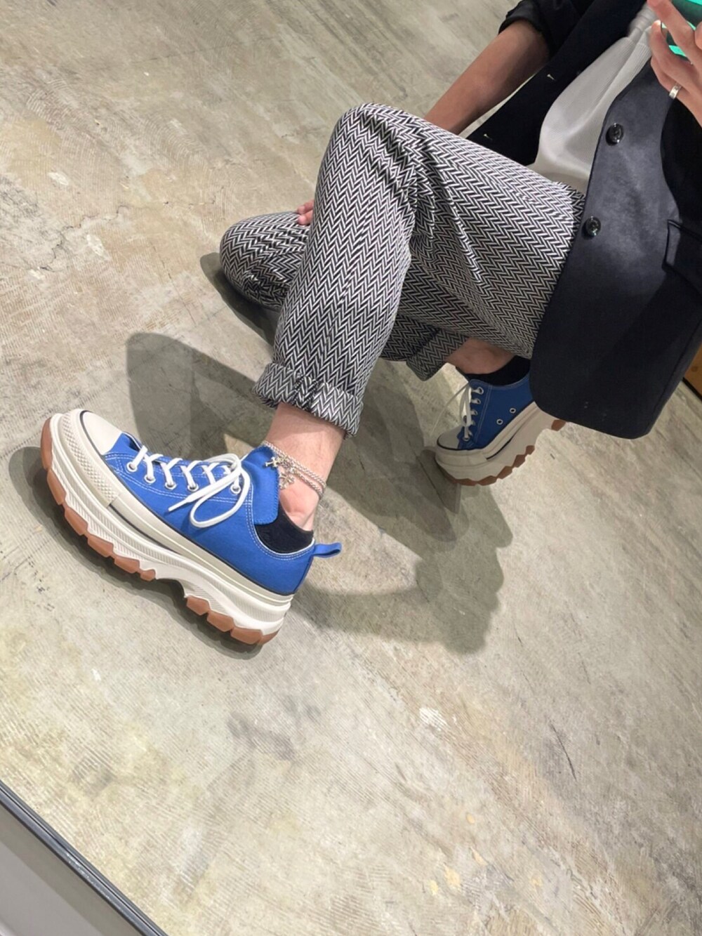 ブラック系のテーラードジャケット、ホワイト系のニット/セーター、グレー系のチノパンツを着用したメンズの秋コーディネートの2枚目の写真