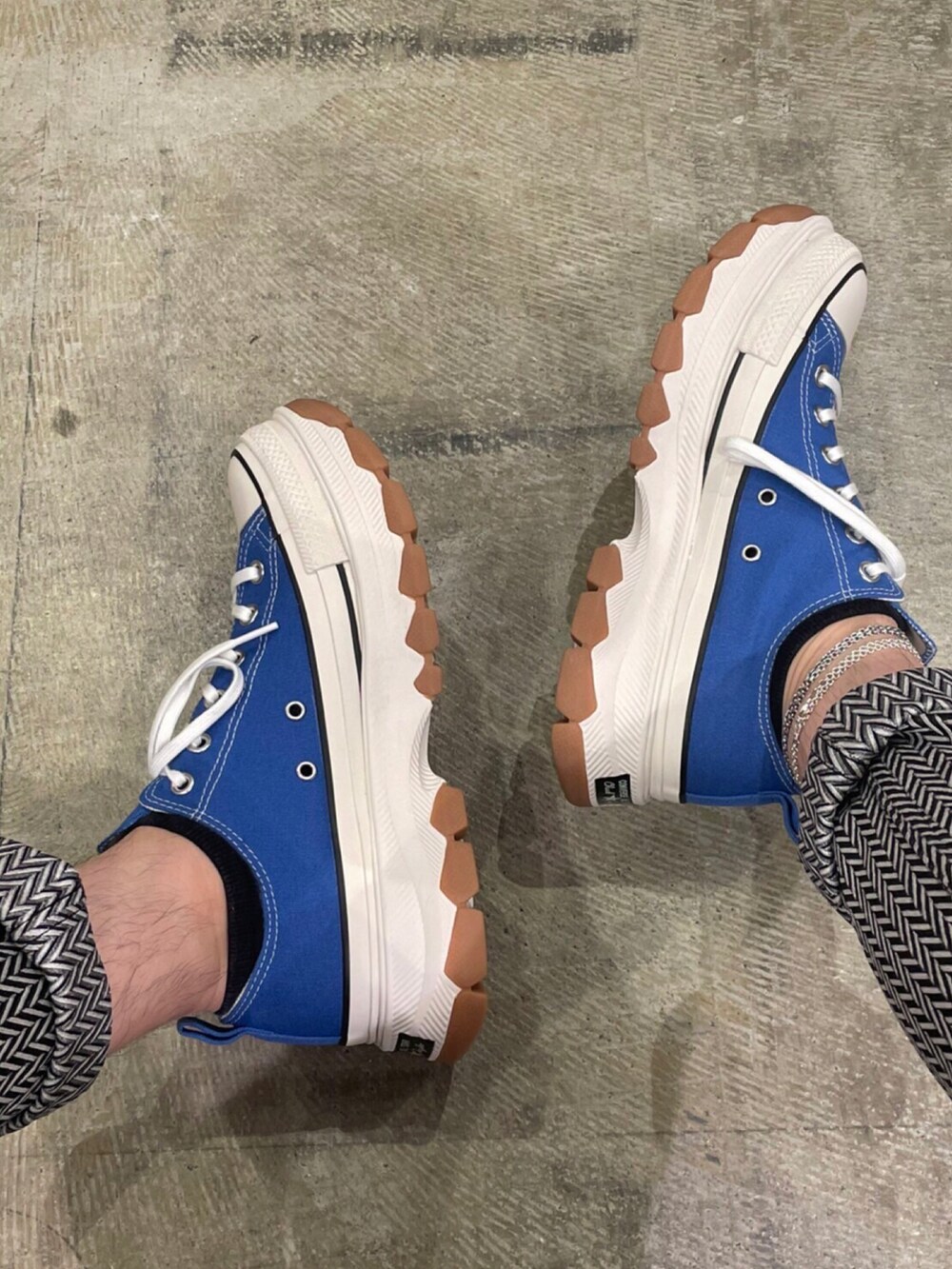 ブラック系のテーラードジャケット、ホワイト系のニット/セーター、グレー系のチノパンツを着用したメンズの秋コーディネートの3枚目の写真