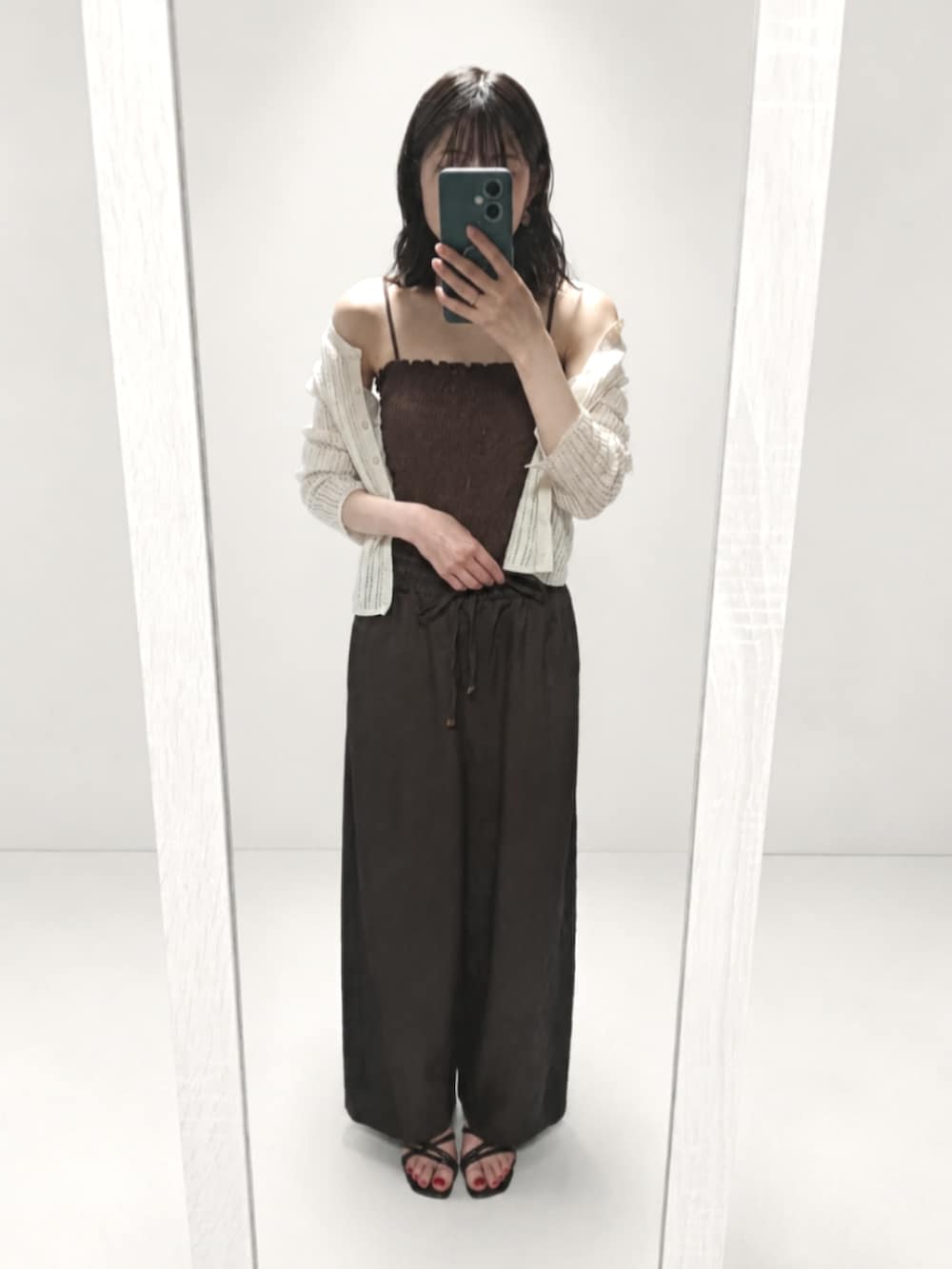 ブラック系のサンダル、ブラック系のショルダーバッグを着用したレディースの夏コーディネートの3枚目の写真