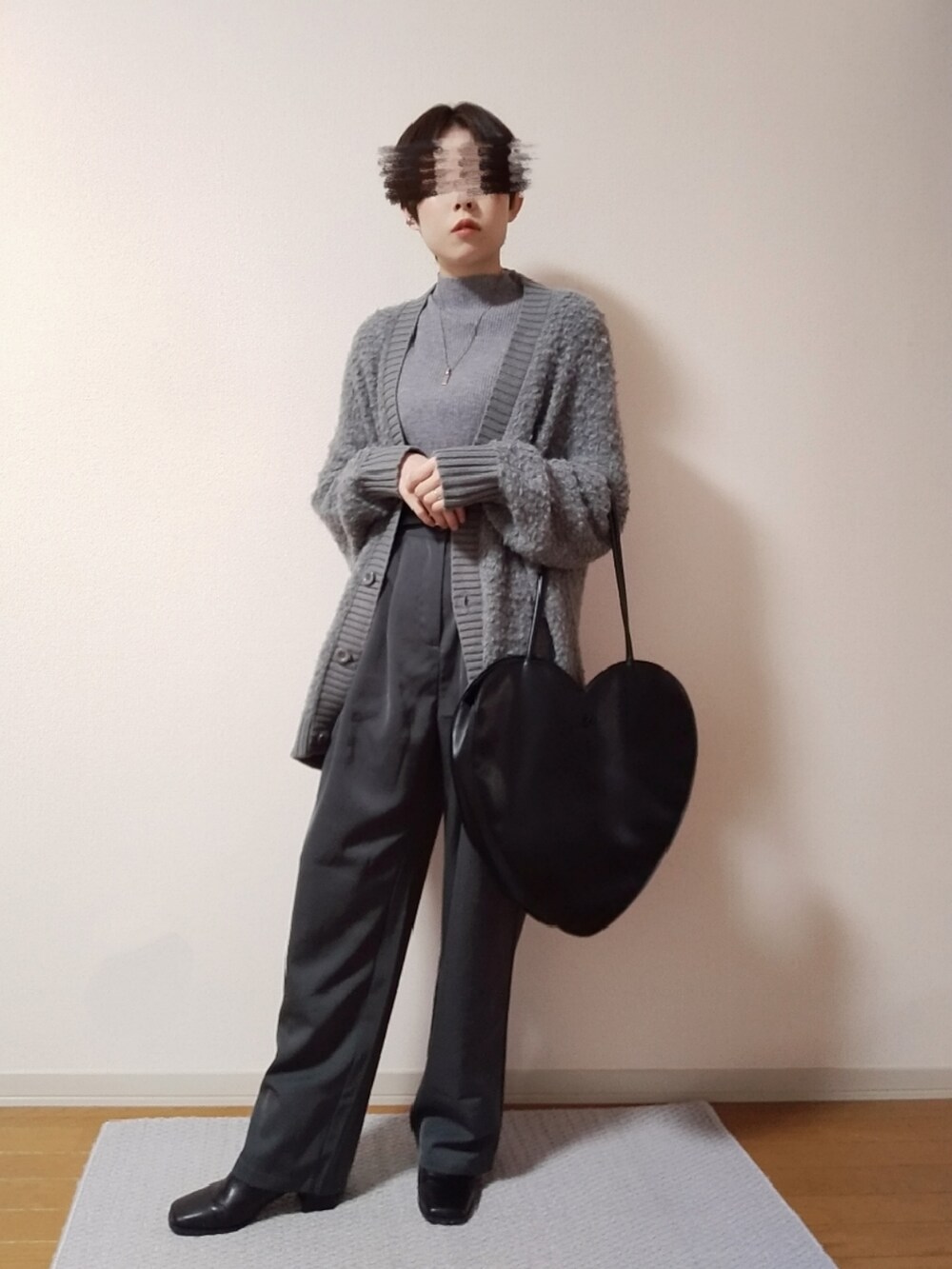 グレー系のニット/セーター、ブラック系のトートバッグ、グレー系のスラックスを着用したレディースの秋コーディネートの2枚目の写真
