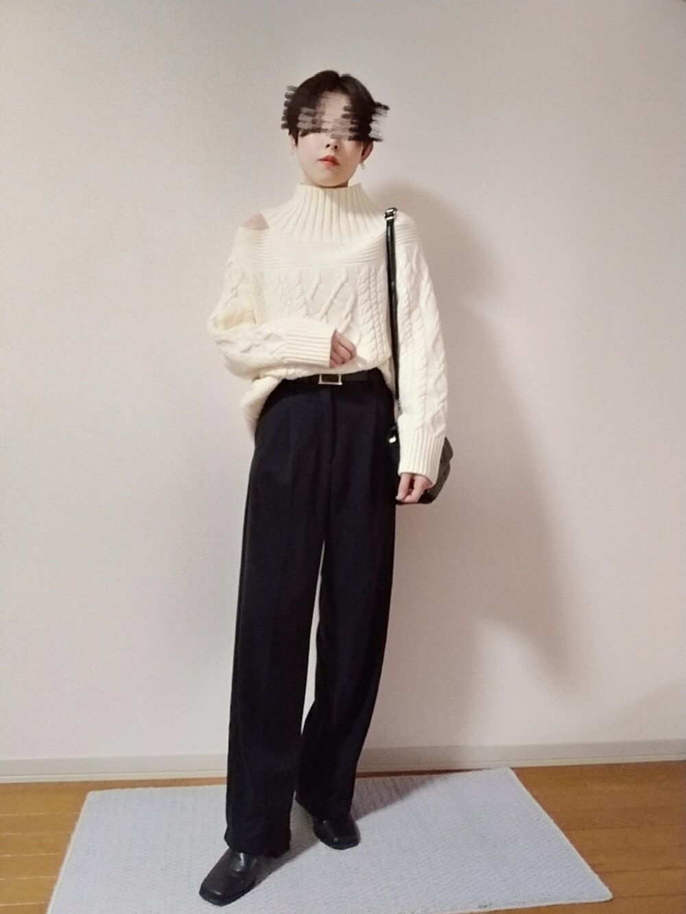 ブラック系のショルダーバッグ、ブラック系のスラックス、ブラック系のブーツを着用したレディースの秋コーディネートの2枚目の写真