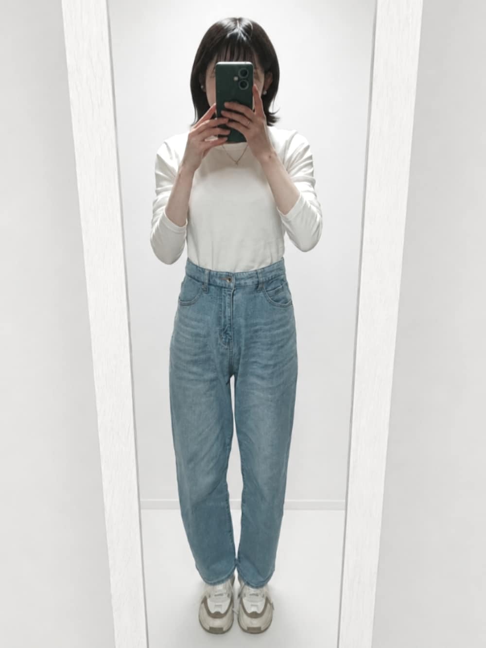 ホワイト系のTシャツ/カットソー、ブルー系のデニムパンツ、ベージュ系のスニーカーを着用したレディースの春コーディネートの3枚目の写真