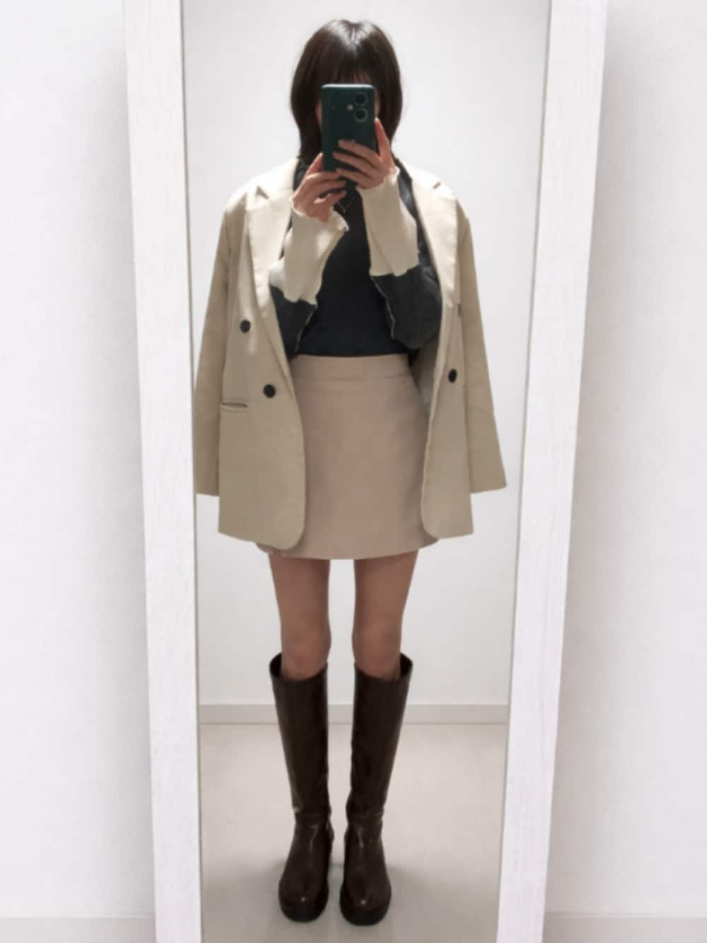 ホワイト系のテーラードジャケット、グレー系のTシャツ/カットソー、ベージュ系のスカートを着用したレディースの春コーディネートの2枚目の写真