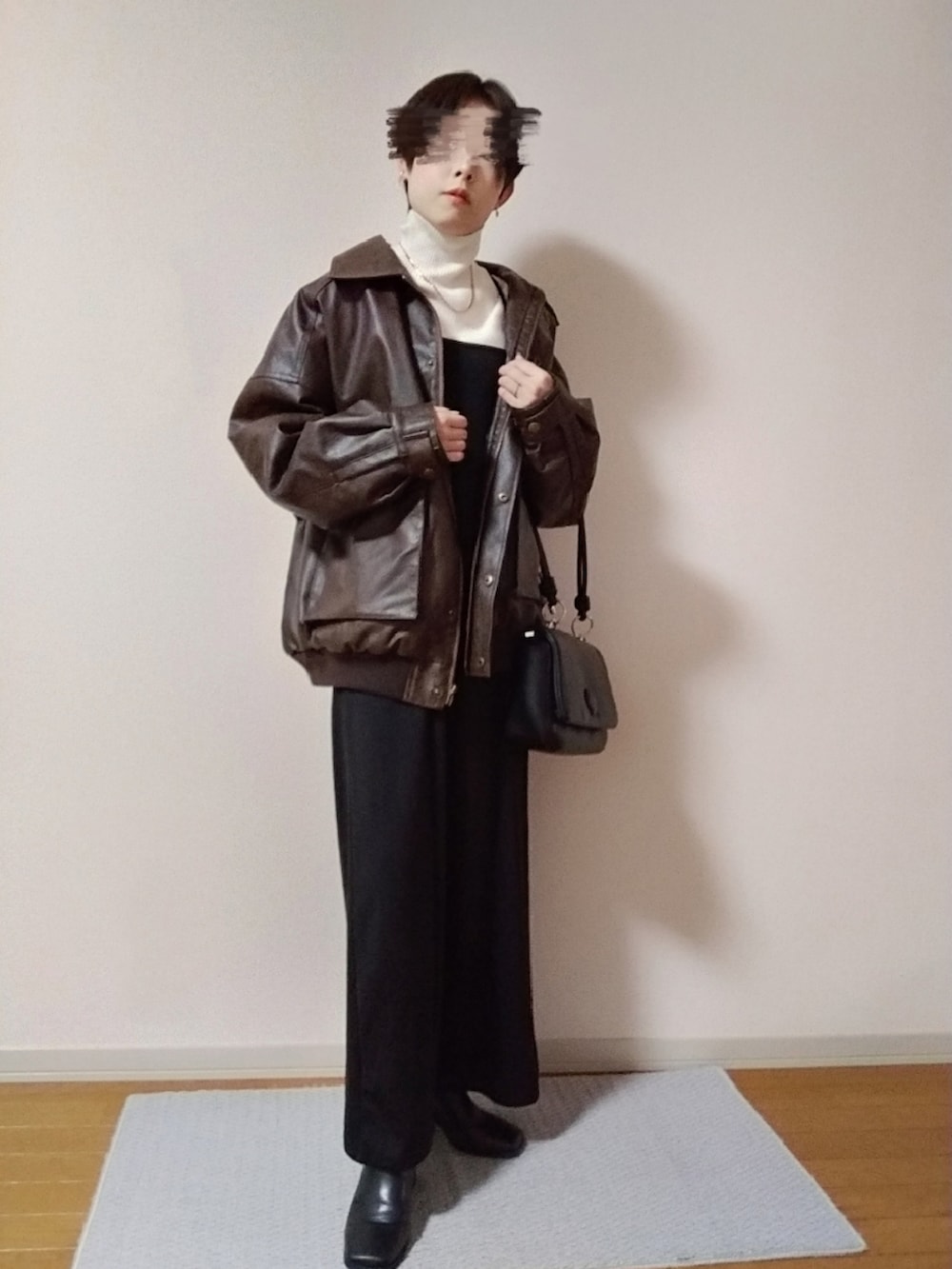 ホワイト系のニット/セーター、ブラウン系のブルゾン、ブラック系のショルダーバッグを着用したレディースの秋コーディネートの3枚目の写真