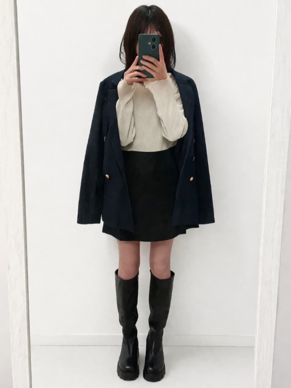 ブルー系のテーラードジャケット、ブラック系のスカート、ブラック系のブーツを着用したレディースの春コーディネートの2枚目の写真
