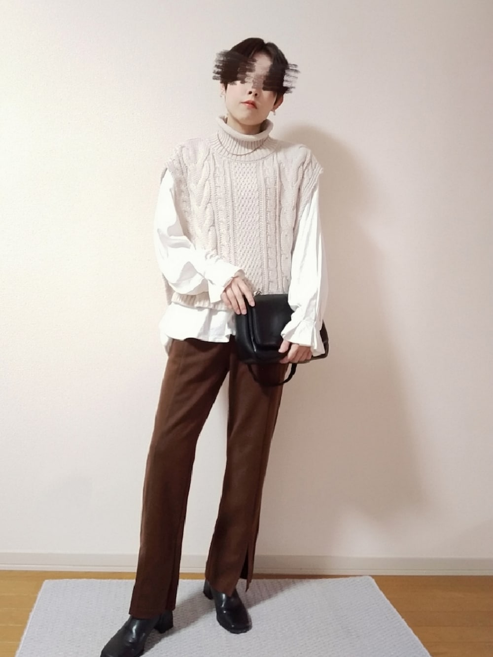 ホワイト系のベスト、ホワイト系のTシャツ/カットソー、ブラック系のショルダーバッグを着用したレディースの秋コーディネートの3枚目の写真