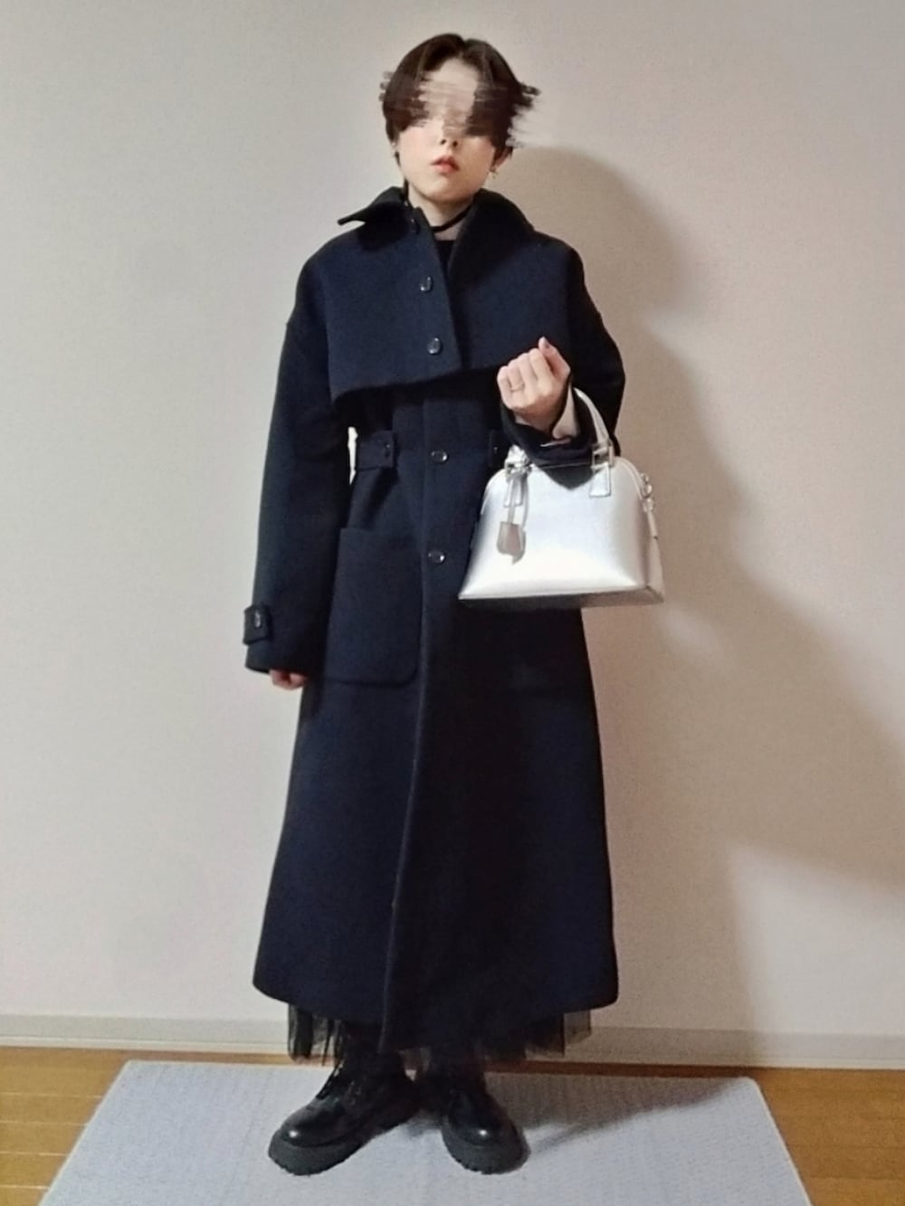 ホワイト系のニット/セーター、ブラック系のショルダーバッグ、ブラック系のブーツを着用したレディースの秋コーディネートの3枚目の写真