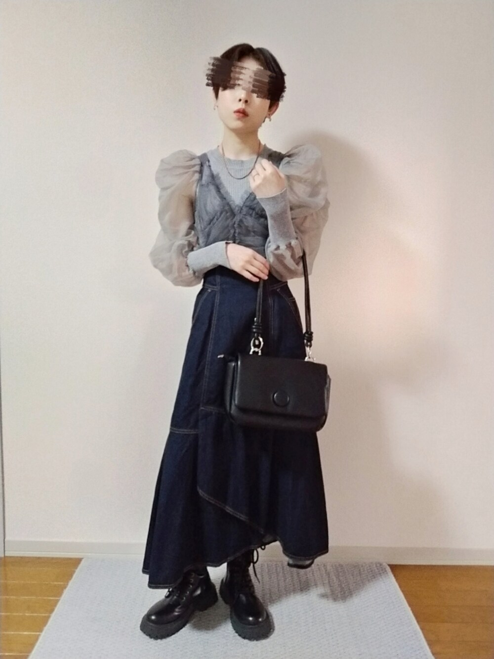 グレー系のニット/セーター、ブラック系のショルダーバッグ、ブルー系のスカートを着用したレディースの秋コーディネートの2枚目の写真