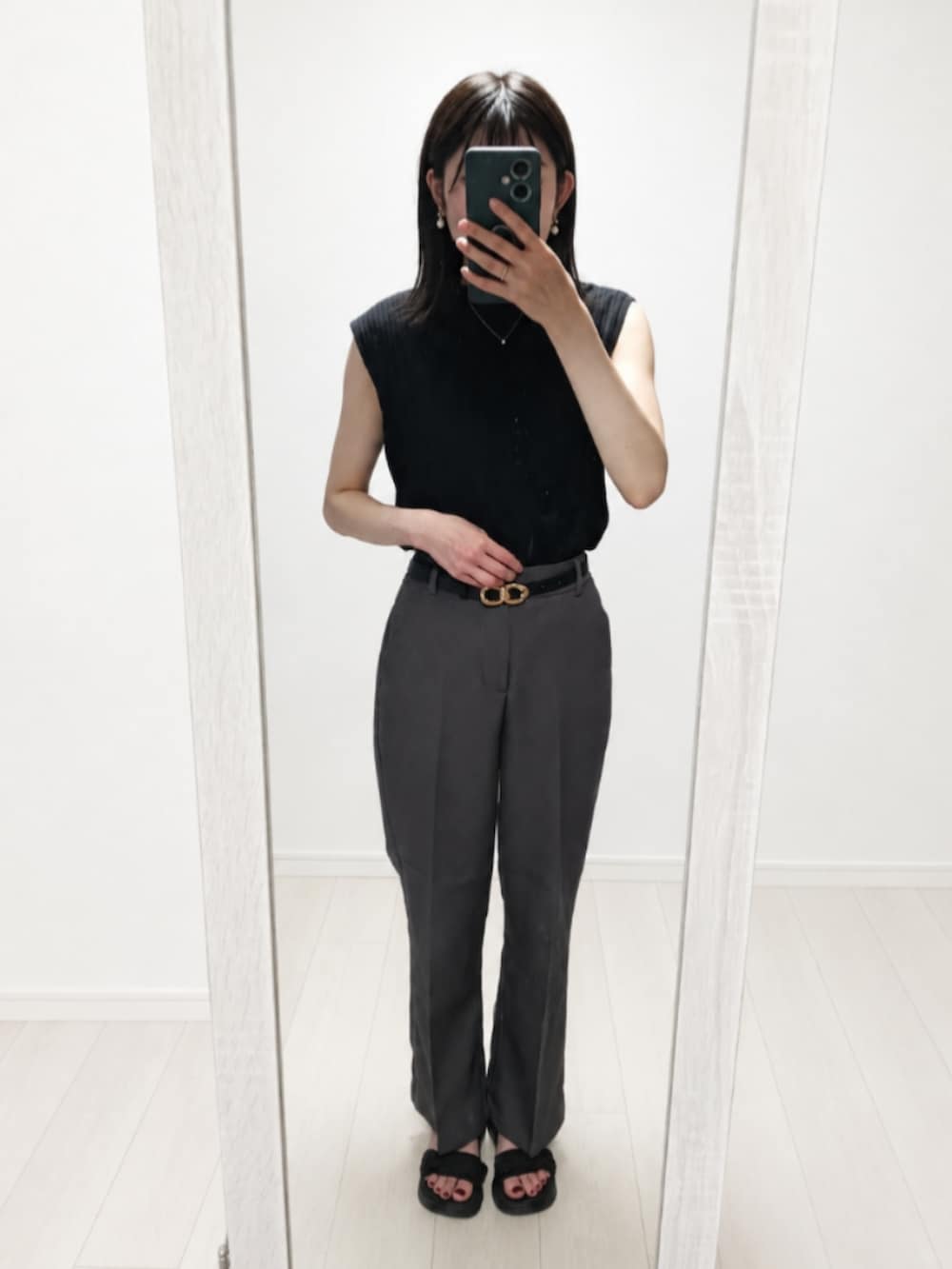 ブラック系のTシャツ/カットソー、グレー系のスラックス、ブラック系のサンダルを着用したレディースの夏コーディネートの2枚目の写真