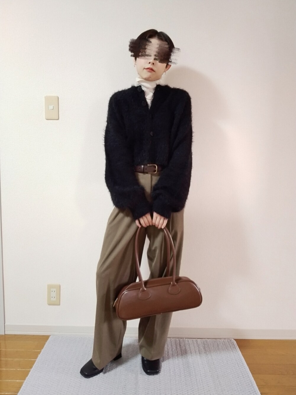 ホワイト系のニット/セーター、ブラック系のカーディガン/ボレロ、その他のスラックスを着用したレディースの秋コーディネートの2枚目の写真