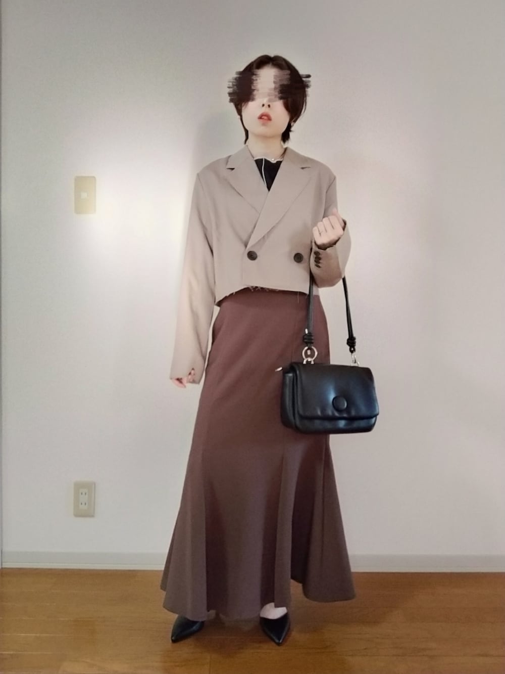 ブラック系のTシャツ/カットソー、ベージュ系のテーラードジャケット、ブラック系のショルダーバッグを着用したレディースの秋コーディネートの2枚目の写真