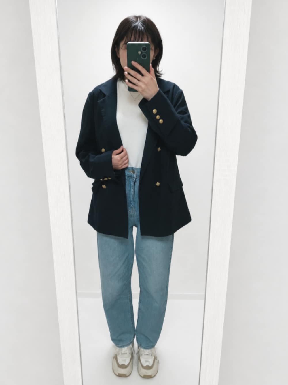 ホワイト系のTシャツ/カットソー、ブルー系のデニムパンツ、ベージュ系のスニーカーを着用したレディースの春コーディネートの2枚目の写真