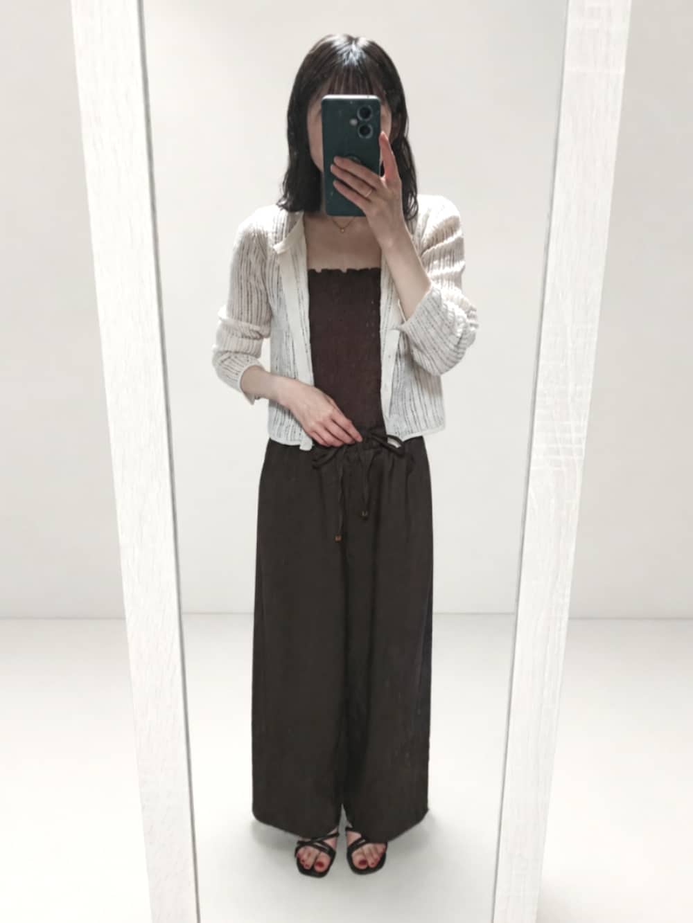 ブラック系のサンダル、ブラック系のショルダーバッグを着用したレディースの夏コーディネートの2枚目の写真
