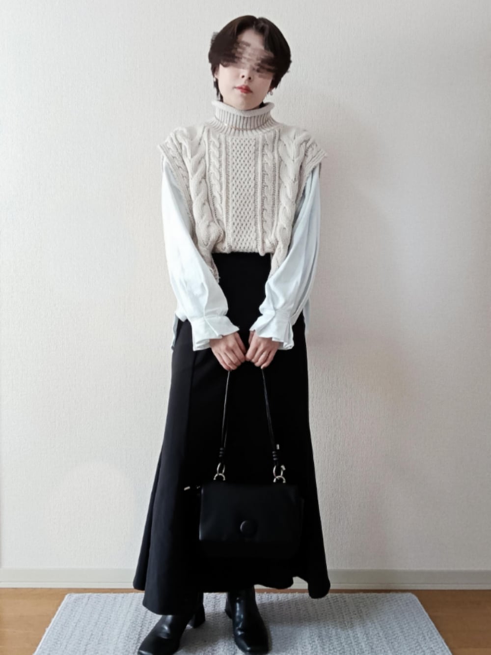 ホワイト系のベスト、ホワイト系のTシャツ/カットソー、ブラック系のショルダーバッグを着用したレディースの秋コーディネートの2枚目の写真