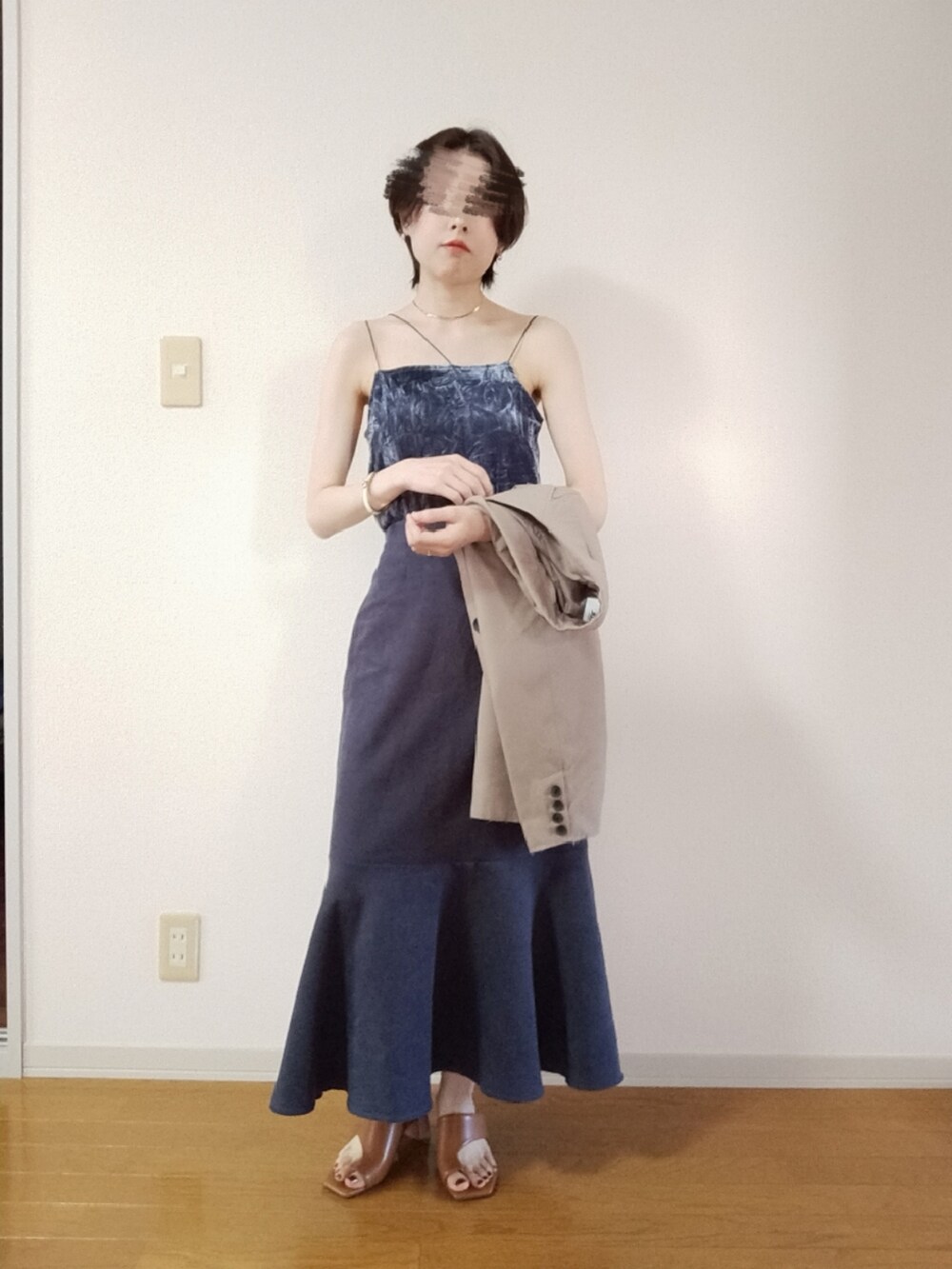 グレー系のキャミソール、ベージュ系のテーラードジャケット、グレー系のスカートを着用したレディースの秋コーディネートの4枚目の写真