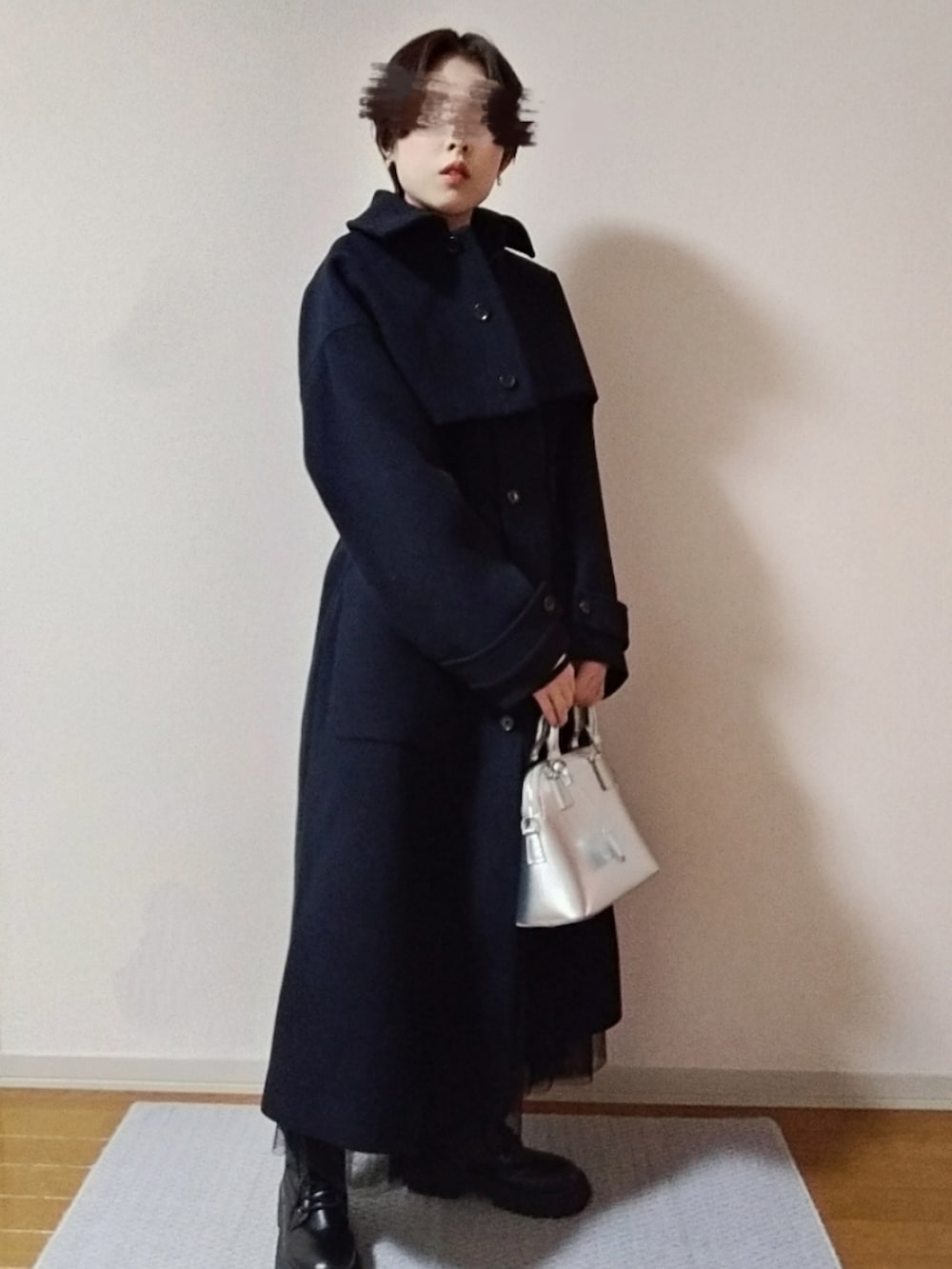 ホワイト系のニット/セーター、ブラック系のショルダーバッグ、ブラック系のブーツを着用したレディースの秋コーディネートの4枚目の写真