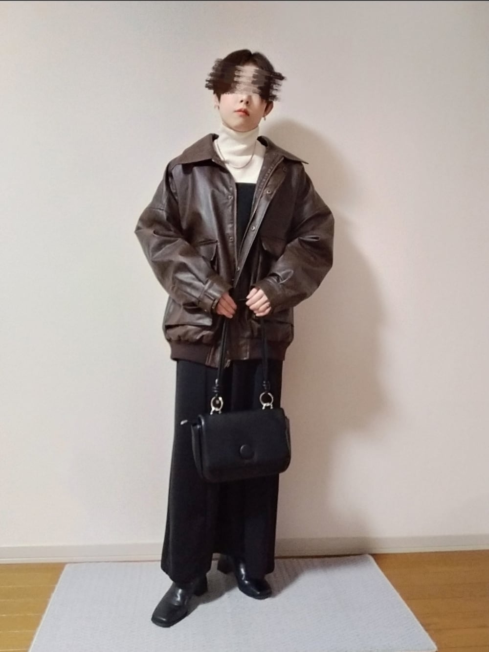 ホワイト系のニット/セーター、ブラウン系のブルゾン、ブラック系のショルダーバッグを着用したレディースの秋コーディネートの2枚目の写真