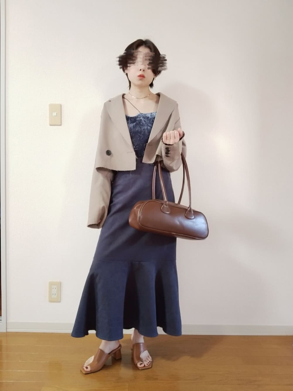 グレー系のキャミソール、ベージュ系のテーラードジャケット、グレー系のスカートを着用したレディースの秋コーディネートの2枚目の写真