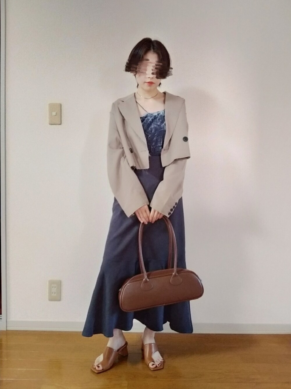 グレー系のキャミソール、ベージュ系のテーラードジャケット、グレー系のスカートを着用したレディースの秋コーディネートの3枚目の写真