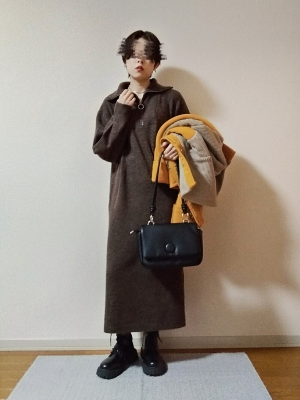 ブラック系のショルダーバッグ、ブラック系のブーツ、ゴールド系のネックレスを着用したレディースの秋コーディネートの3枚目の写真