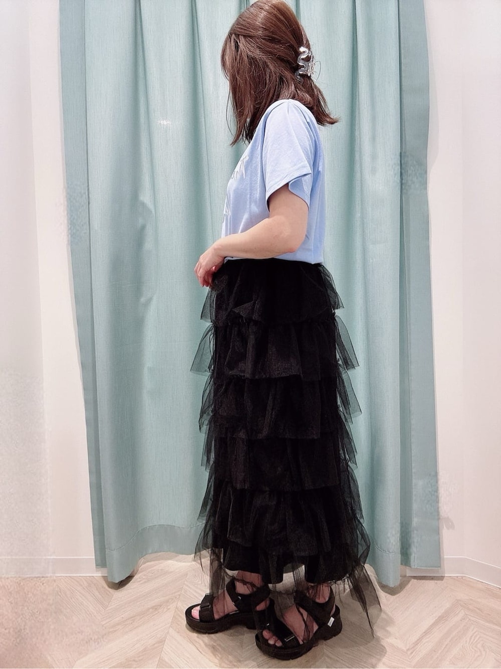 ブルー系のTシャツ/カットソー、ブラック系のスカート、ブラック系のサンダルを着用したレディースの夏コーディネートの2枚目の写真