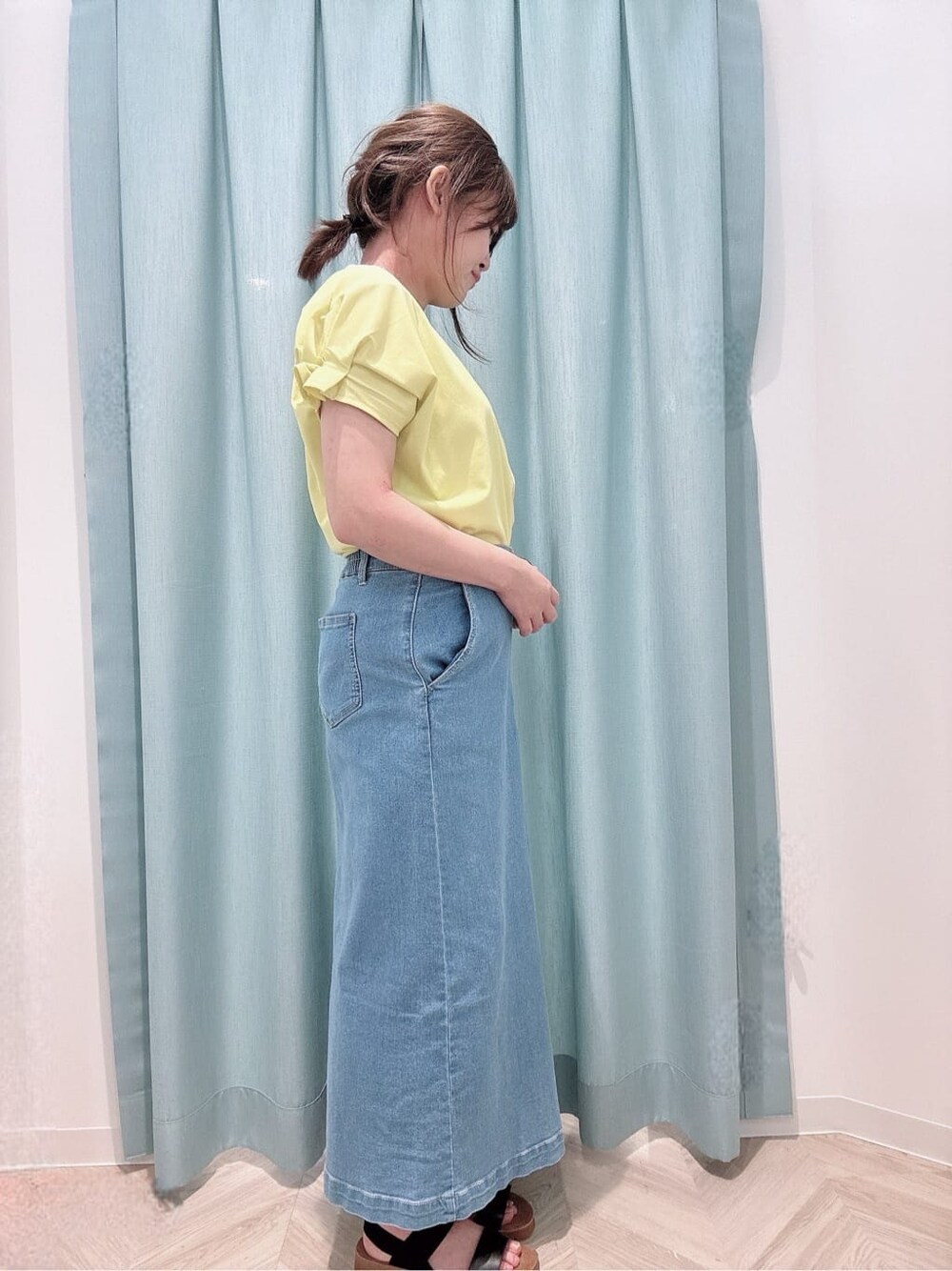 イエロー系のTシャツ/カットソー、ブルー系のデニムスカート、ブラック系のサンダルを着用したレディースの夏コーディネートの2枚目の写真