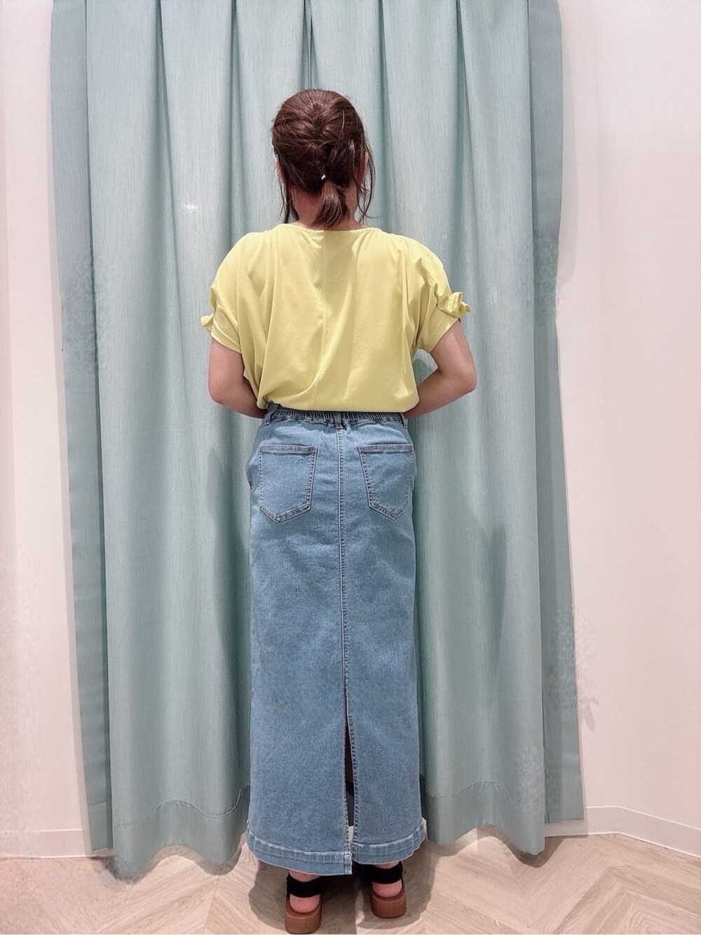イエロー系のTシャツ/カットソー、ブルー系のデニムスカート、ブラック系のサンダルを着用したレディースの夏コーディネートの3枚目の写真