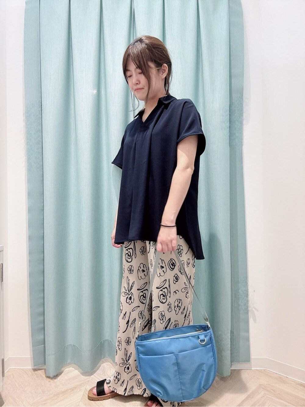 ベージュ系のその他パンツ、ブラック系のサンダル、ブルー系のショルダーバッグを着用したレディースの夏コーディネートの2枚目の写真