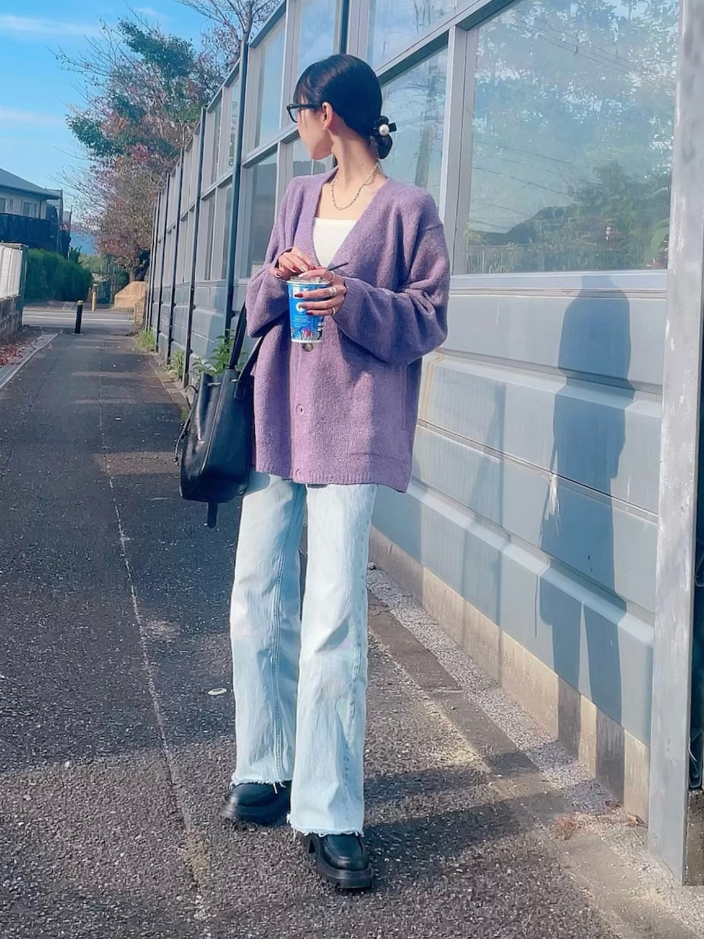 ブルー系のデニムパンツ、ブラック系のローファー、ブラック系のショルダーバッグを着用したレディースの秋コーディネートの2枚目の写真