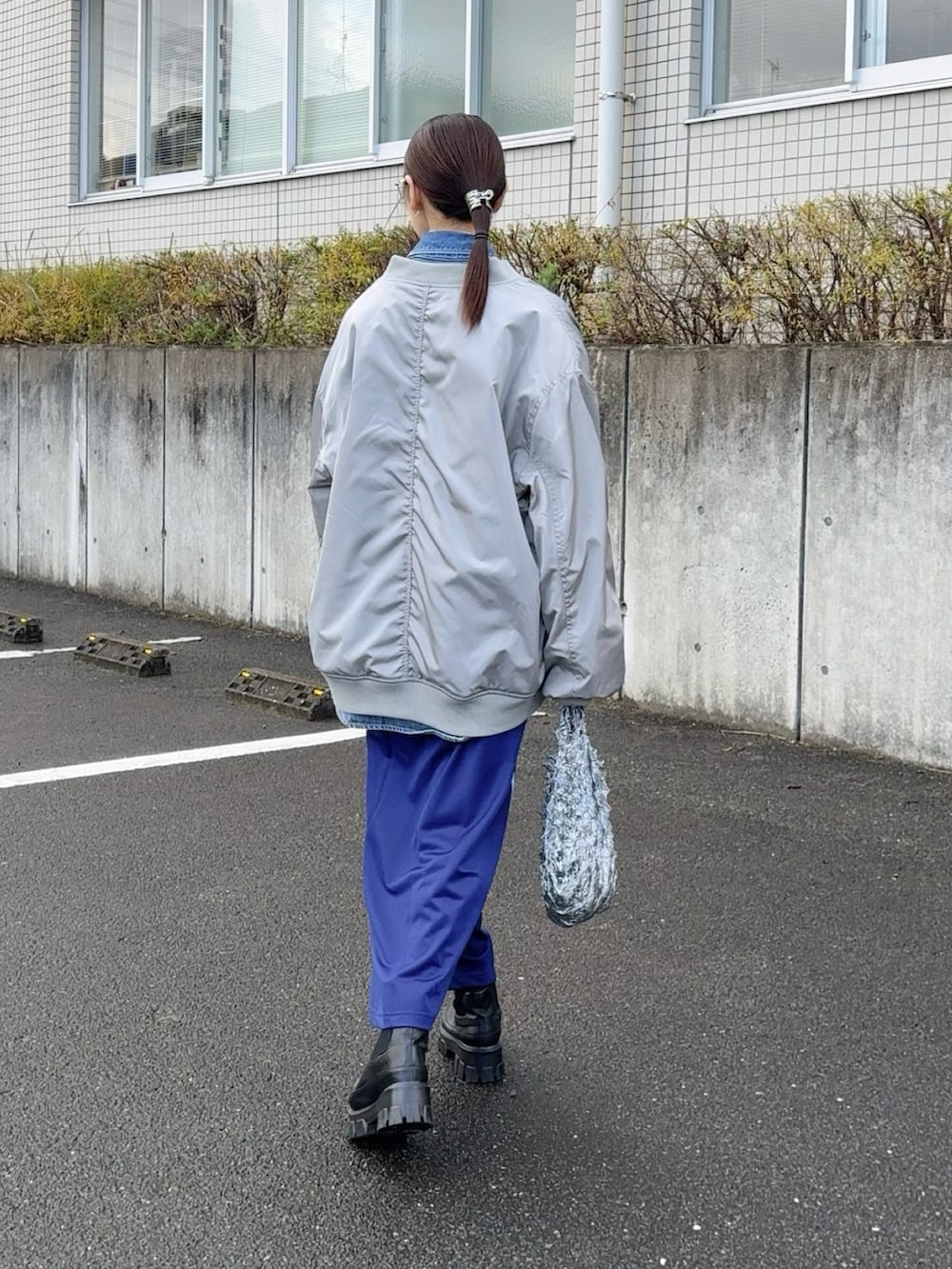 グレー系のMA-1、ブルー系のシャツ/ブラウス、シルバー系のバッグを着用したレディースの冬コーディネートの2枚目の写真