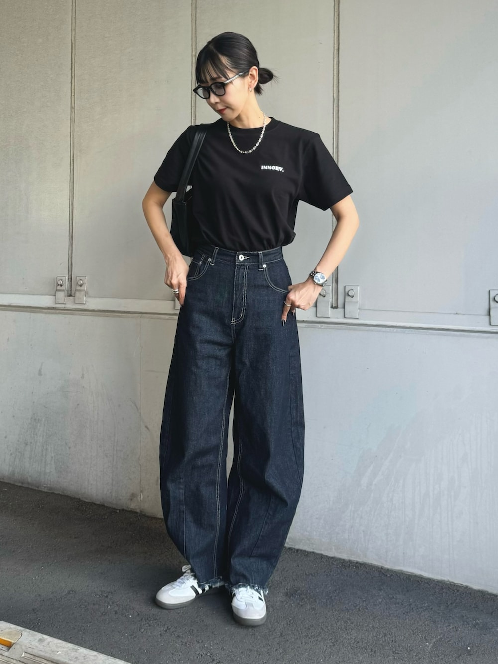 ブラック系のTシャツ/カットソー、ブルー系のデニムパンツ、ホワイト系のスニーカーを着用したレディースの夏コーディネートの3枚目の写真