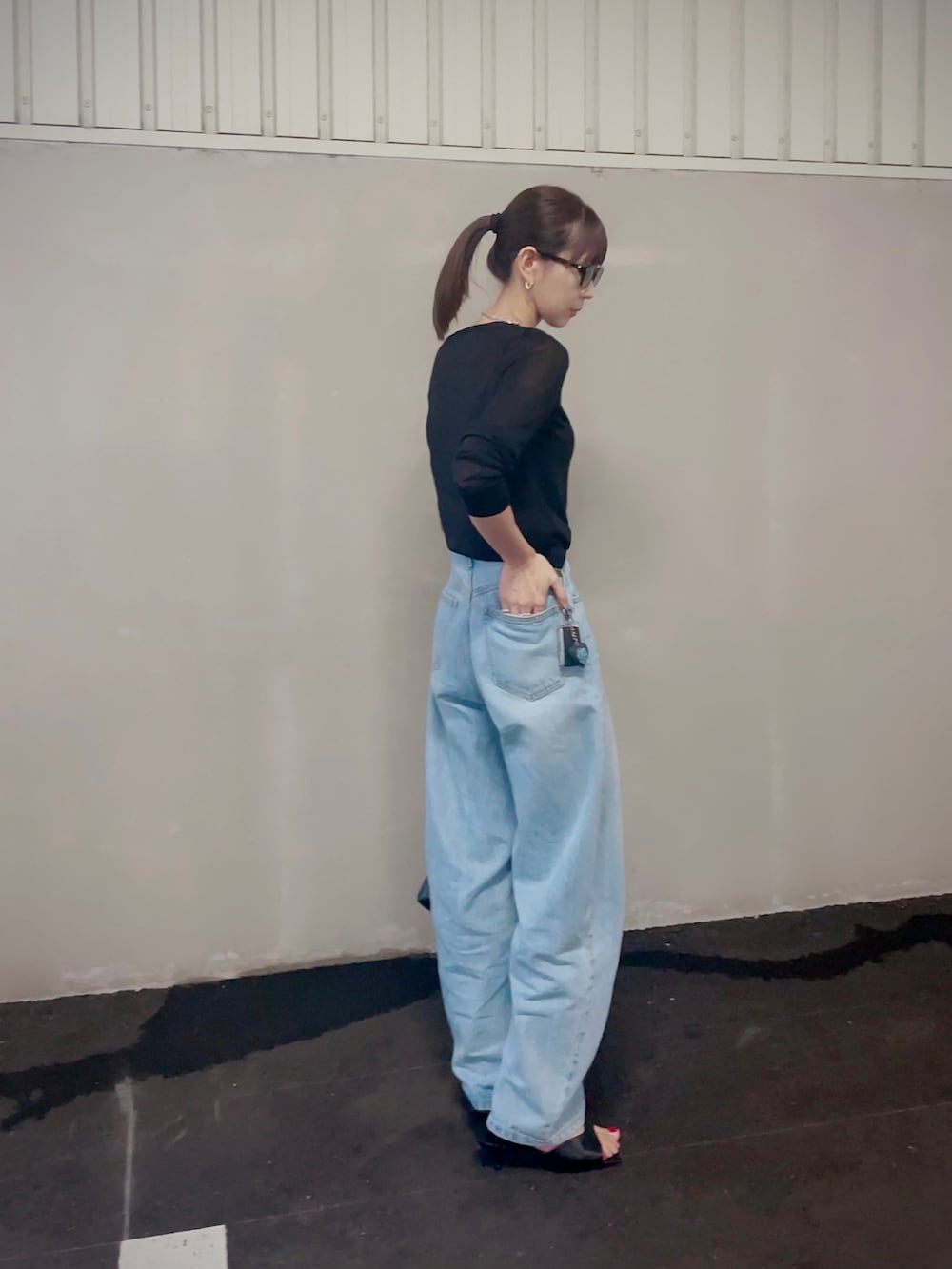 ブルー系のデニムパンツ、ブラック系のショルダーバッグ、ブラック系のカーディガン/ボレロを着用したレディースの秋コーディネートの3枚目の写真