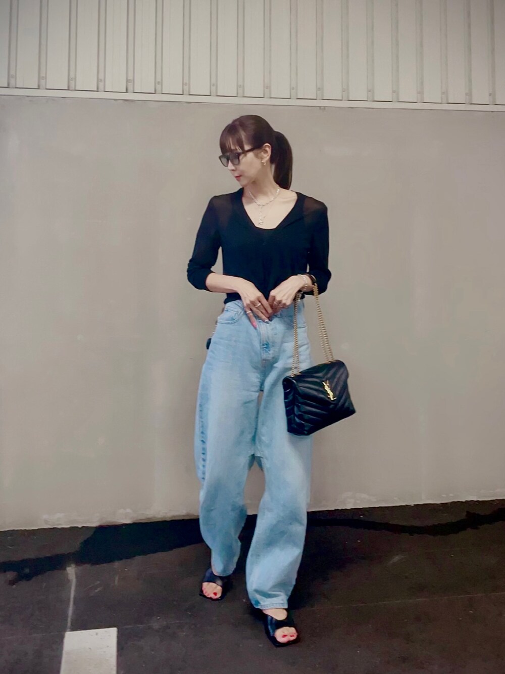 ブルー系のデニムパンツ、ブラック系のショルダーバッグ、ブラック系のカーディガン/ボレロを着用したレディースの秋コーディネートの4枚目の写真