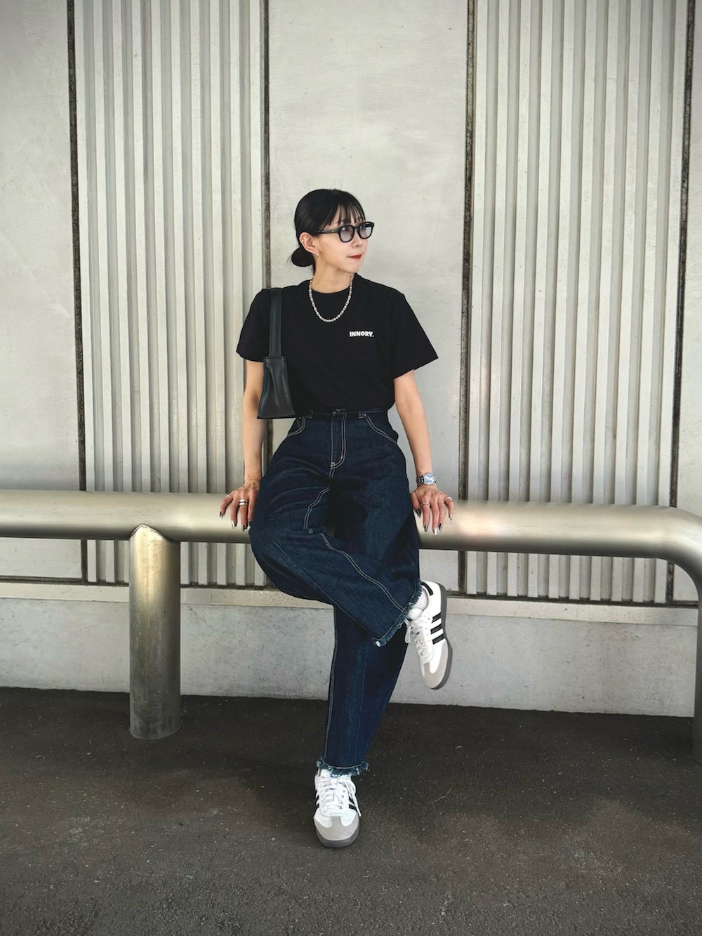 ブラック系のTシャツ/カットソー、ブルー系のデニムパンツ、ホワイト系のスニーカーを着用したレディースの夏コーディネートの4枚目の写真