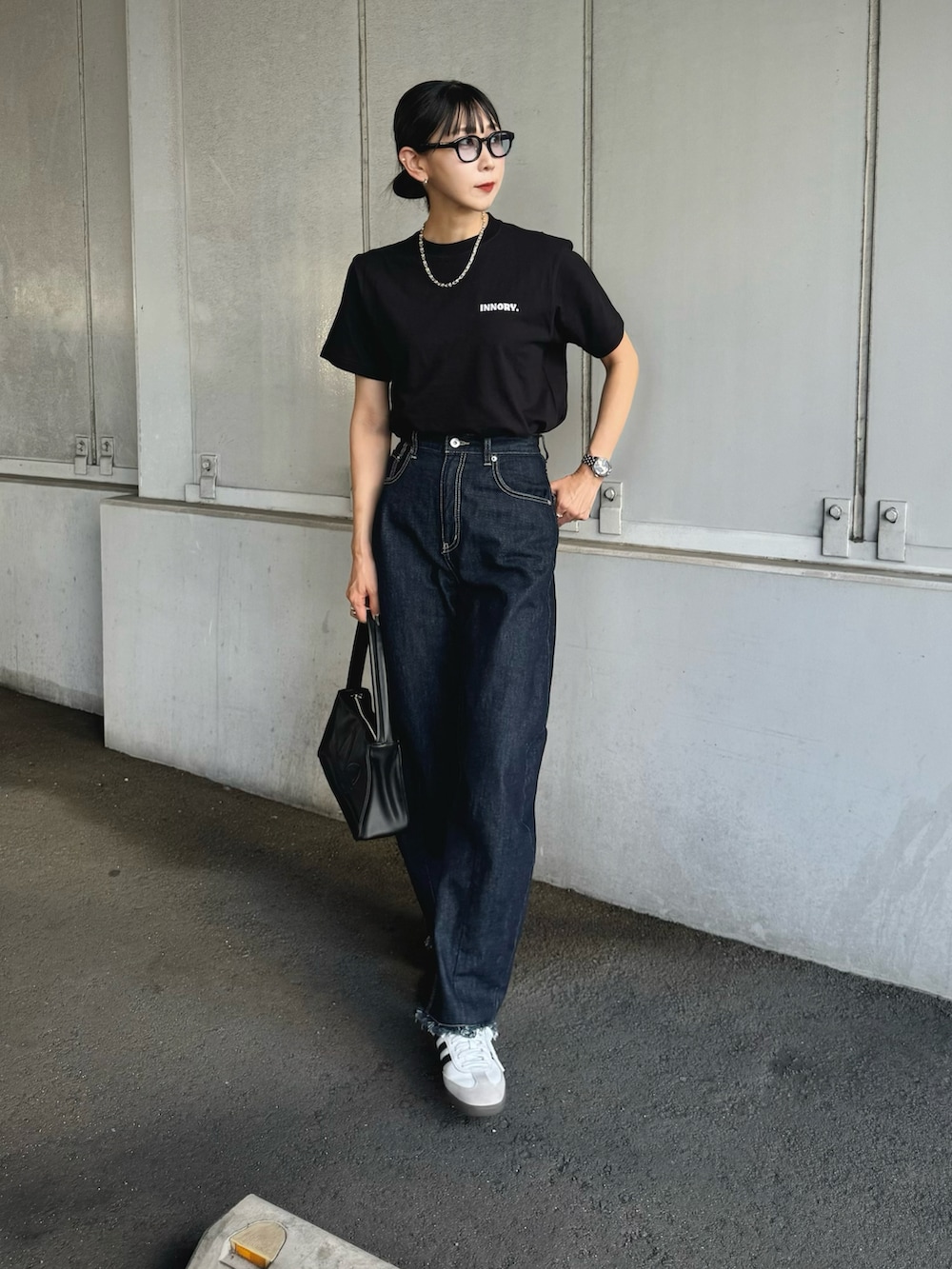 ブラック系のTシャツ/カットソー、ブルー系のデニムパンツ、ホワイト系のスニーカーを着用したレディースの夏コーディネートの2枚目の写真