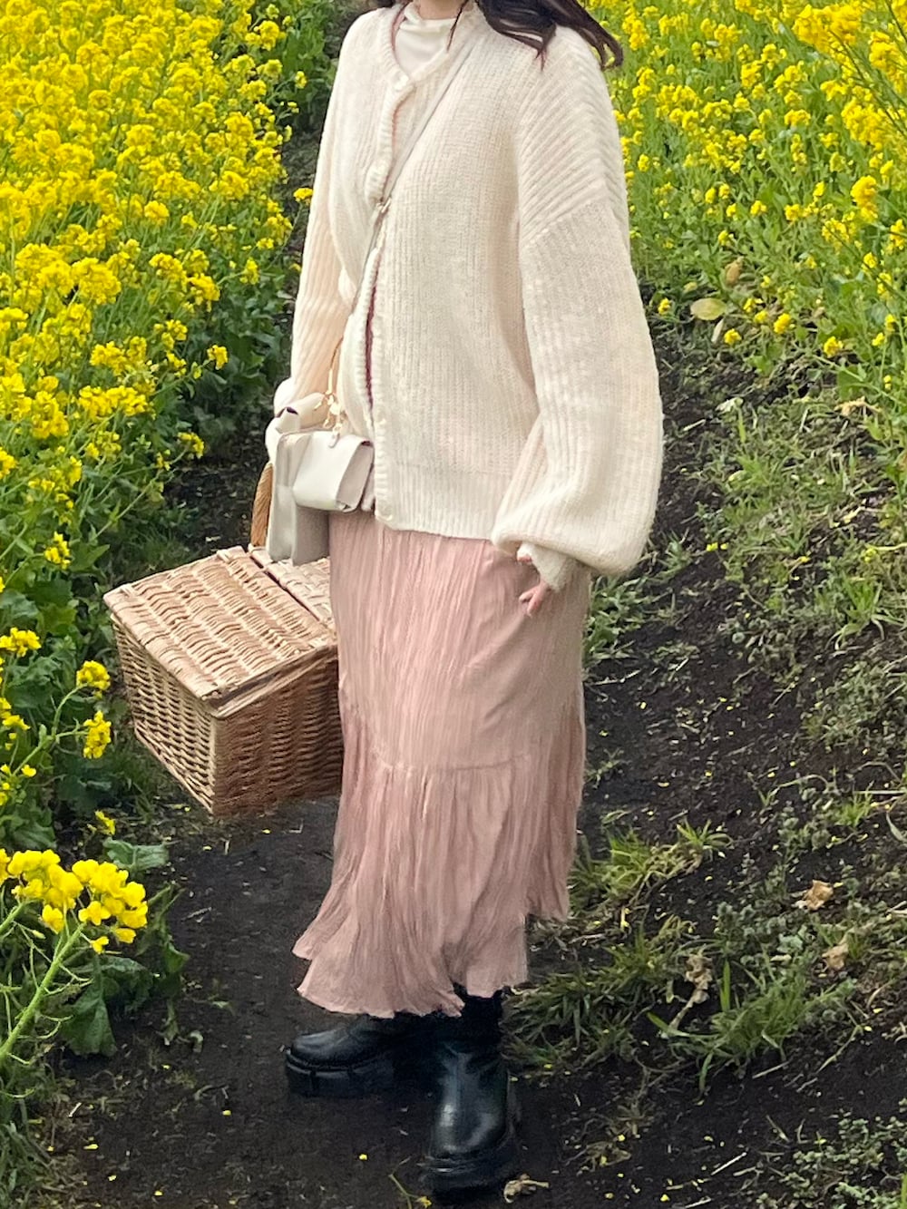 ホワイト系のカーディガン/ボレロ、ベージュ系のワンピース、ブラック系のブーツを着用したレディースの春コーディネートの2枚目の写真