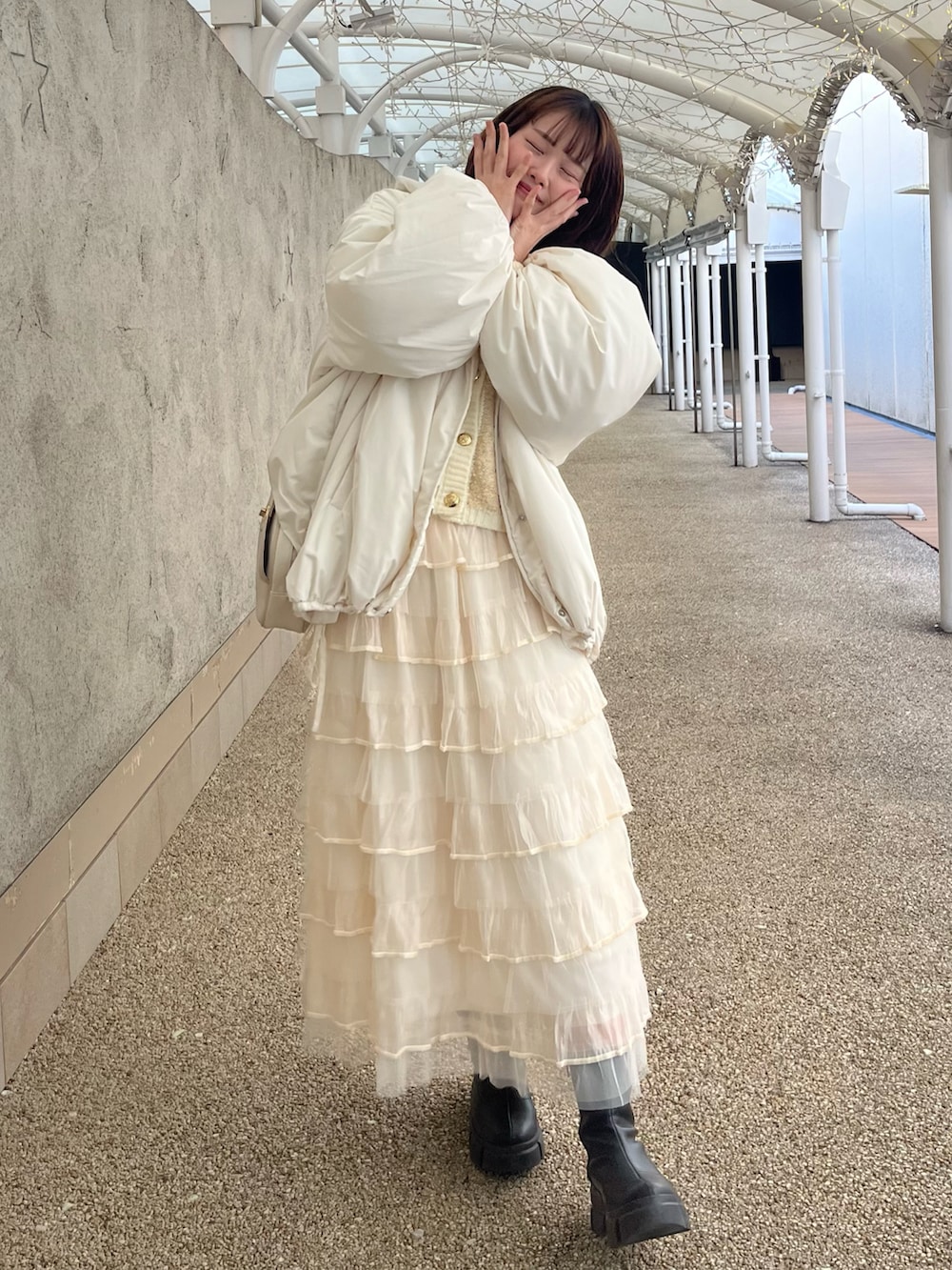ホワイト系のブルゾン、ホワイト系のカーディガン/ボレロ、ホワイト系のスカートを着用したレディースの冬コーディネートの2枚目の写真