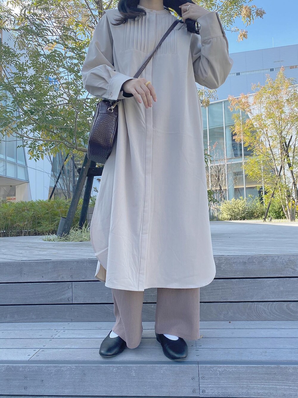 ブラック系のバレエシューズ、ベージュ系のパンツ、ブラウン系のトートバッグを着用したレディースの秋コーディネートの2枚目の写真