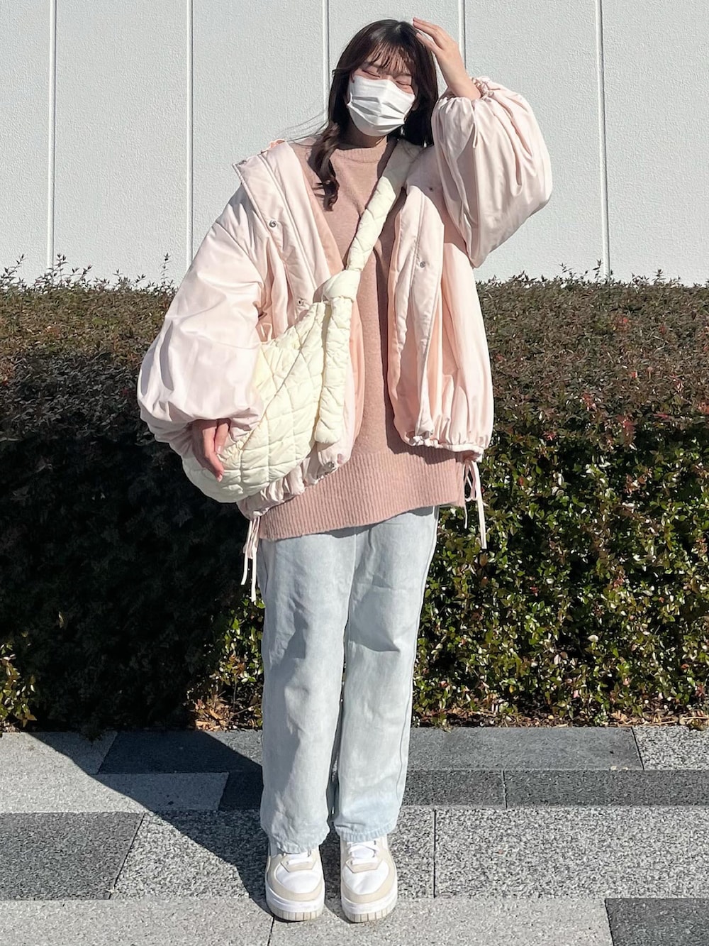 ホワイト系のショルダーバッグ、ピンク系のブルゾン、ピンク系のニット/セーターを着用したレディースの冬コーディネートの2枚目の写真