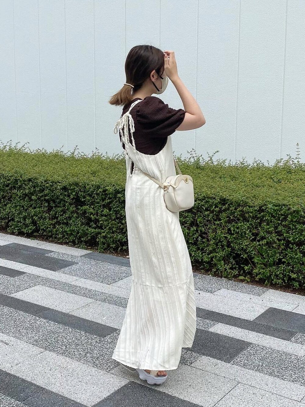 ホワイト系のワンピース、ホワイト系のサンダル、ホワイト系のショルダーバッグを着用したレディースの秋コーディネートの2枚目の写真